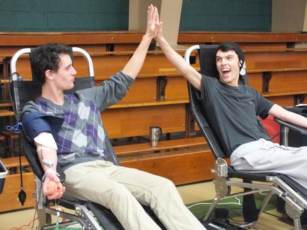 Mitchell Patterson(12) slaps a high five to Justin Griego(12) while giving their blood to the Penrose Medical Center for patients.