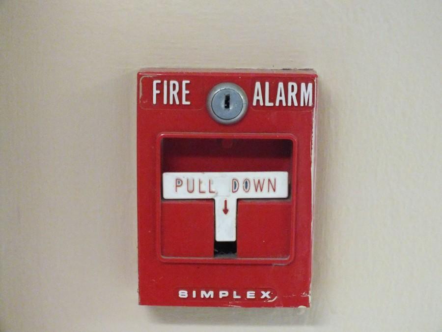 Fire alarm pull down levers are placed in various spots on the school walls.