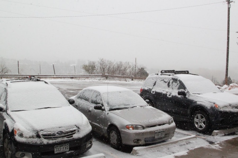 The cars parked at the high school were covered with snow.