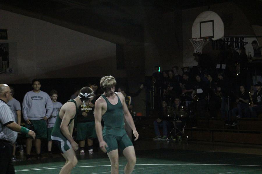 Billy Ryan (12) stands back up after pinning his opponent for the win.