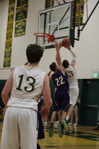 Senior Steven Jensen goes for a layup while Sophomore Davyn Adamscheck watches from behind. 