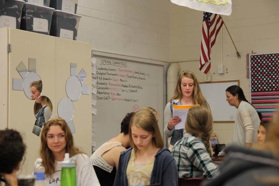 Sophie Kilroy, senior class vice president candidate, presents her ideas on changing the dress code in an official student council meeting. Bailey Visscher-Nickerson, junior class vice president candidate, and Misty Kerze (12) listen. 