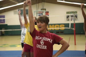 Ryan Murdock (12) leads a cheer at an early-season practice. The team has a new coach this year, Kaitlyn McTamney. McTamney hopes to change the aesthetic of the cheerleaders, making them more serious athletes and teaching them better technique. 