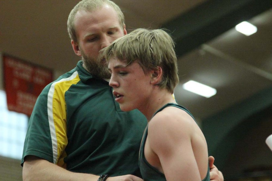 Coach Borkowski consoles Jacob McCarley (9) after a loss. McCarley lost both of his matches.