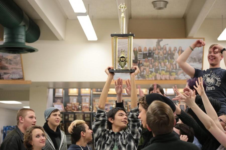 Matt Rivera (11) hoists the first place trophy above his head as the rest of the cast begins to cheer and reach toward it. Rivera has been heavily involved in Manitous theatre department since middle school, and played a significant role in this years fall play, A Servant of Two Masters.