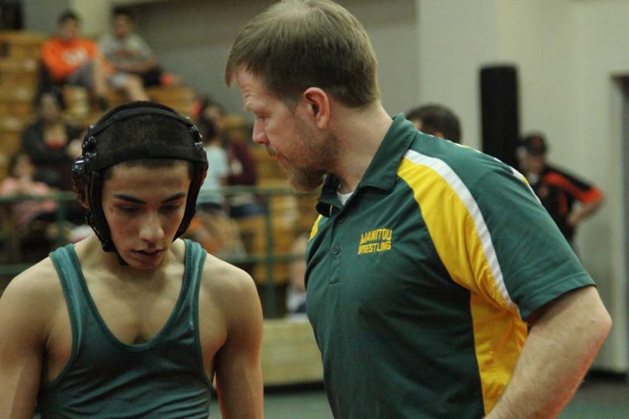 Mr. Bonner, one of the wrestling coaches, discusses tactics and performance with Ceasar Sanchez (10).