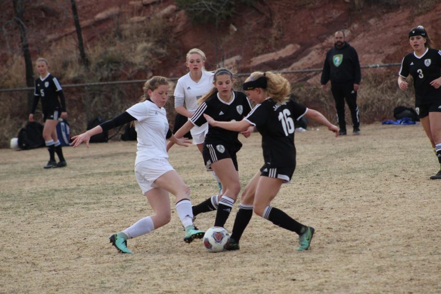 Caileen Sienknecht (10) pursues the ball, going up against a Jefferson Academy player. Sienknecht has been playing varsity soccer since her freshman year at Manitou, and has proven herself to be a powerful asset on the field.