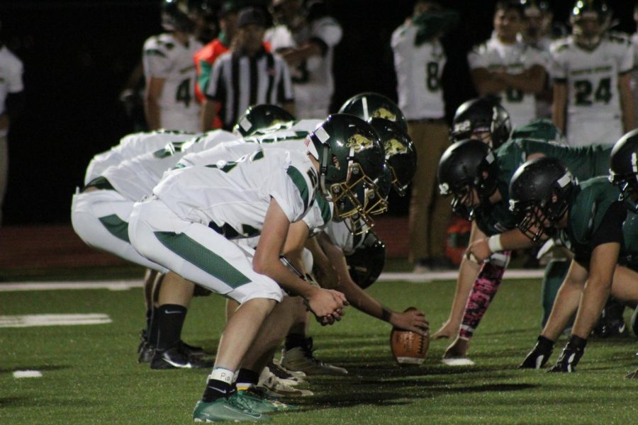 The Mustangs face the Pirates and ready themselves moments before the ball is snapped.