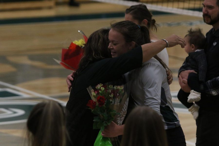 Senior captain Teagan Nevada receives flowers and a hug from her coach, Jane Squires.