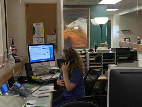 Stacy Thomson, in her new office, answers the phone and signs in students at the beginning of the 2021-2022 school year.  