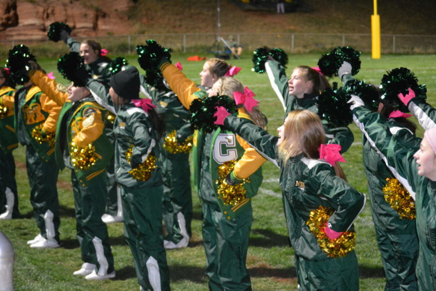 Manitou Springs High School cheerleaders, get the crowd involved in cheering on the football team at Richardson Field, Friday, October 15, 2021.  Many former cheerleaders watched from the stands this year.