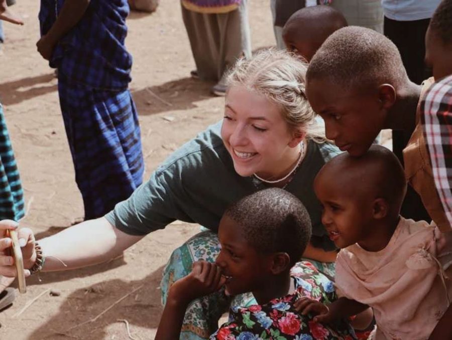 Carroll+takes+a+selfie+with+kids+%28Michael+and+Doris%29+at+a+Maasai+village+while+on+her+trip.%0A