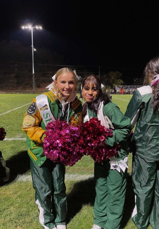 Grace McCumber and Clarissa Snow prepare to cheer on the sidelines of the senior night football game on Friday, Oct. 28.