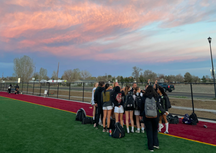 The varsity girls huddle up for a team talk under the sunset. On May 2 the girls won their game
against Eagle Ridge, even after rain delays.