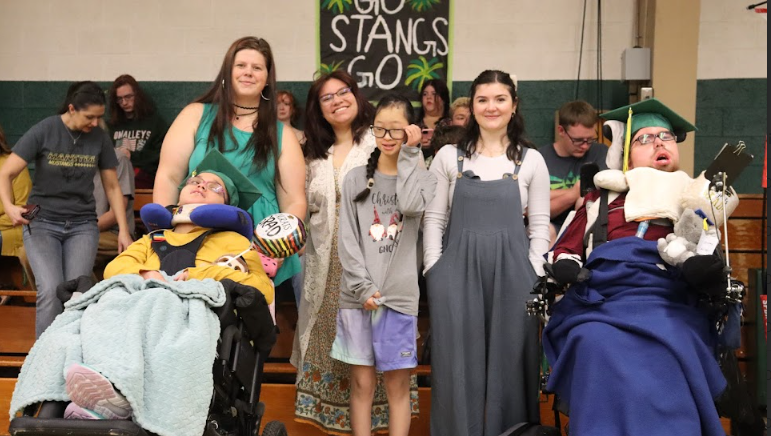 Paraprofessionals Talor Goodloe, Lane Ramsay, Izabeth Mumford and student Gwendolyn Keir support Jazmyn Webb-Everly and Jeremy Morriset-Everly at their high school graduation.  The ceremony was held during Advisory on Friday, May 3.