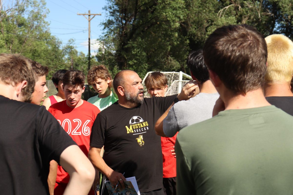 Head varsity coach Ben Mack directs his varsity players during early on practice.