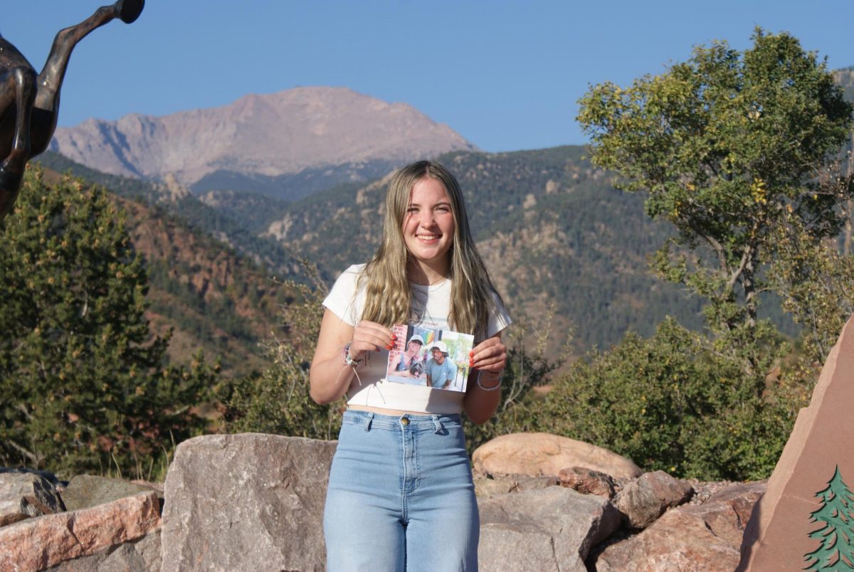 Tori Greene (12) poses for a photo with one of her photos that she took of people from the street.