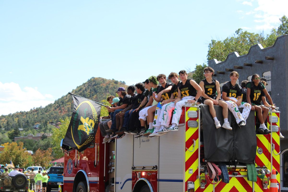 The football team sits on the firetruck in the homecoming.