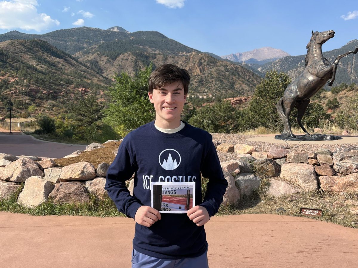 Kyle Blasi (11) holds photo that he took for his photography class titled "Manitou on Track."