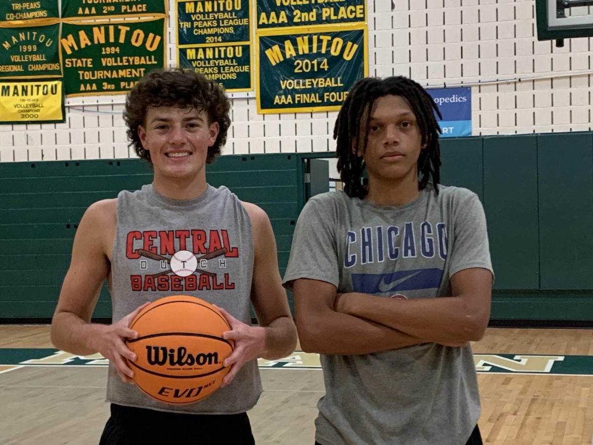 Preston Rhodes and Cohen Barrett stand with a basketball in the gym.