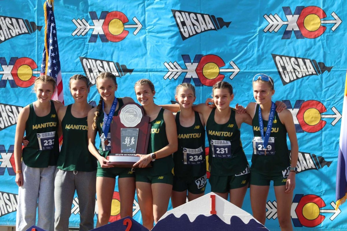 The girls cross country team stand together with their state runner up trophy.