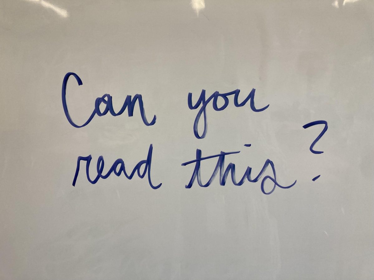 "Can you read this" written on a white board in cursive.