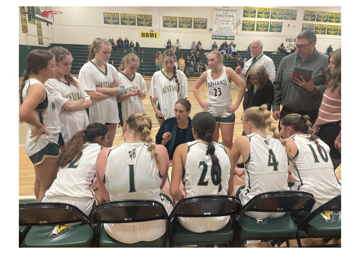 The girls basketball team surrounds Coach Gabby during a game.