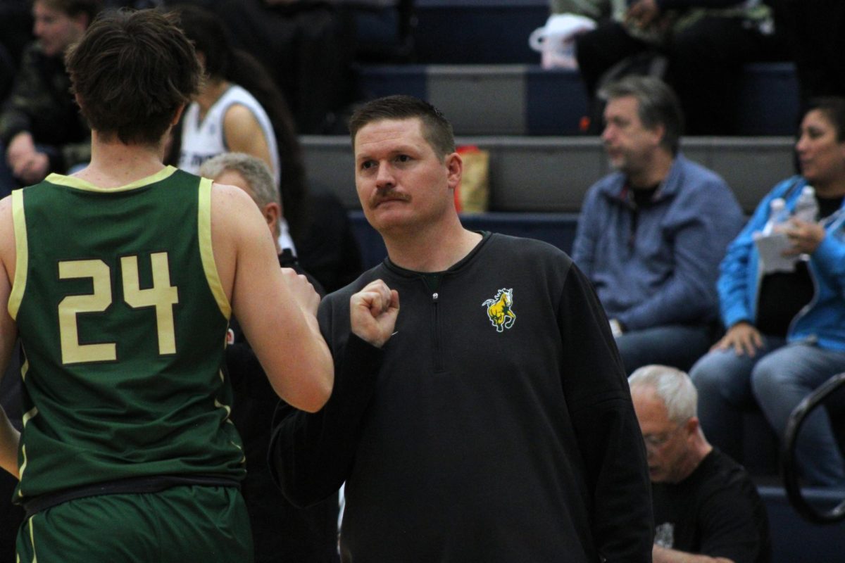 Coach Nick Nunley fist bumps Thomas Spraggins (12) during their game.