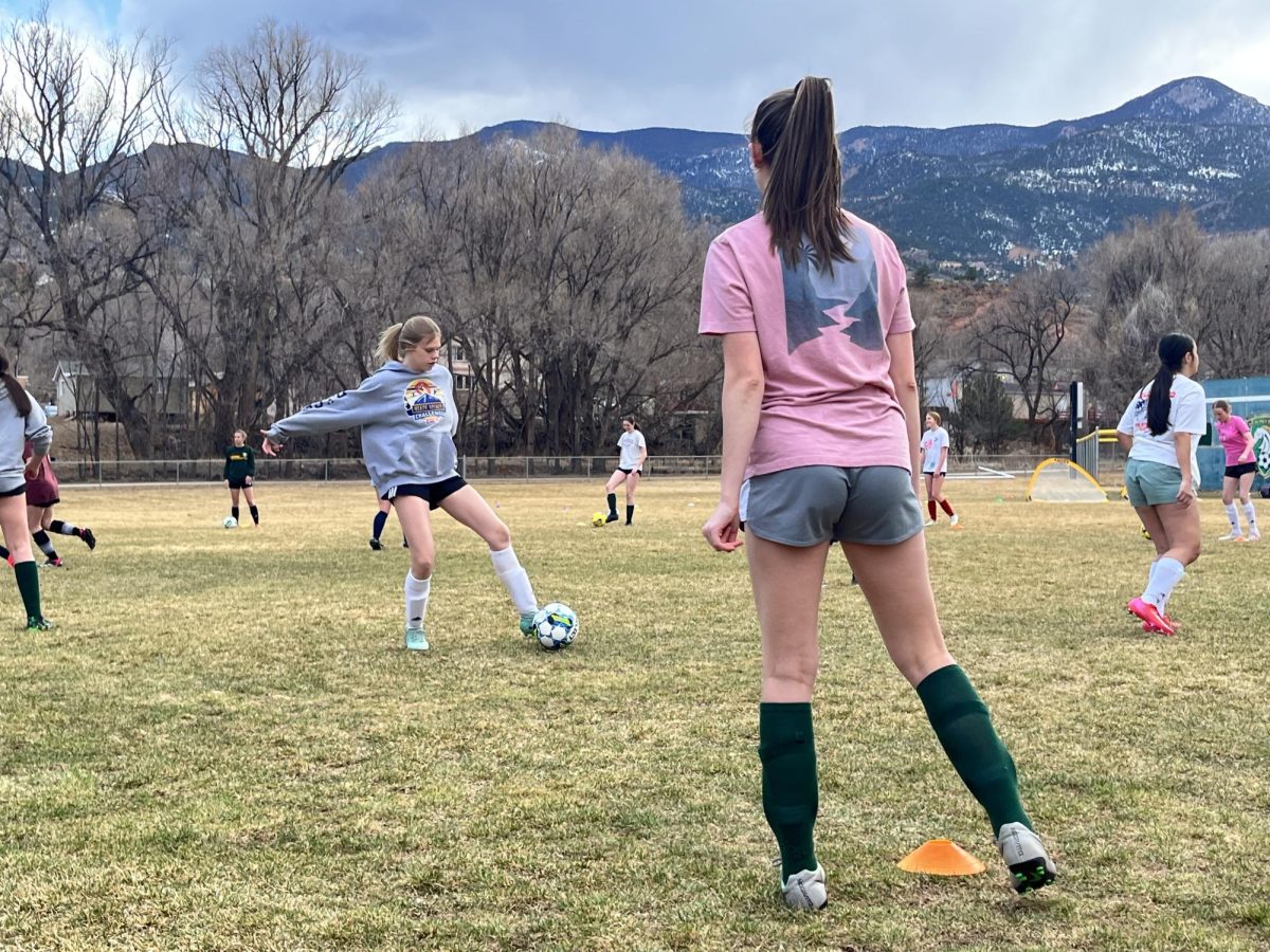 Emma Wall (9) and Heather Larsen (12) practice soccer at Maestes Field with their teammates on March 3 to improve kicking accuracy while moving.