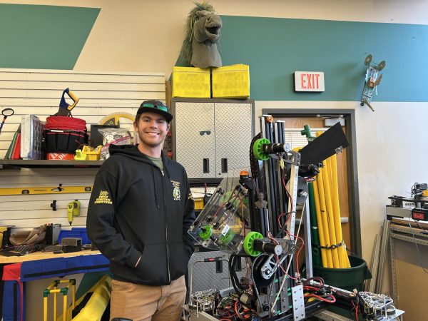 Griffin Saulsbury (12), captain of the Manitou Springs High School robotics team poses next to robat made by the team.