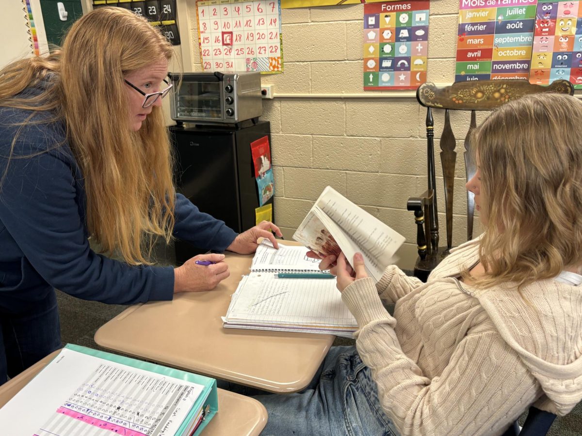 In Angela Shelton's 2B English II class, Shelton helps Claire Walz (10) with her English assignment.