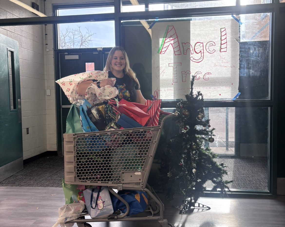 Krissy Stout (12) stands with the gifts donated for the Angle Tree project.