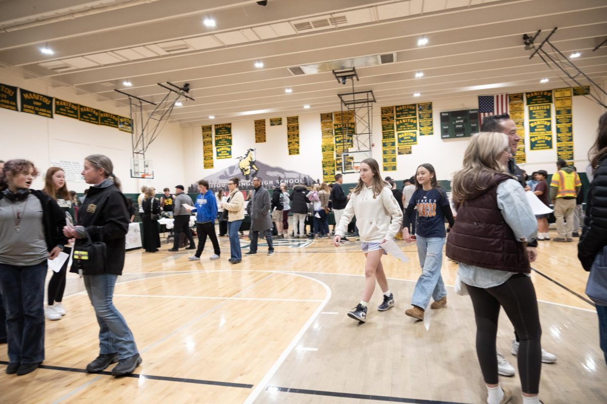 Incoming students and families go to tables to learn about activities offered at MSHS during Welcome Night.