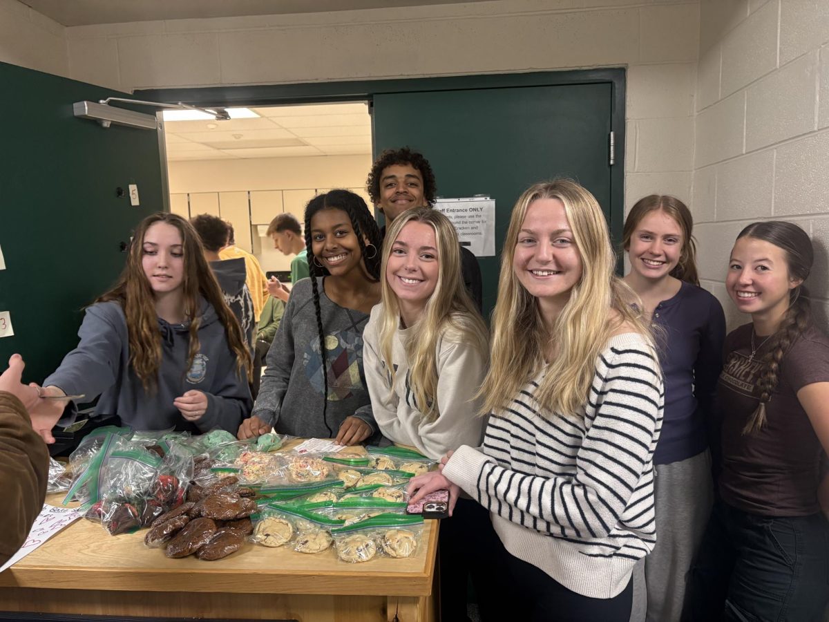 Spanish Club members stand around a bake sale.