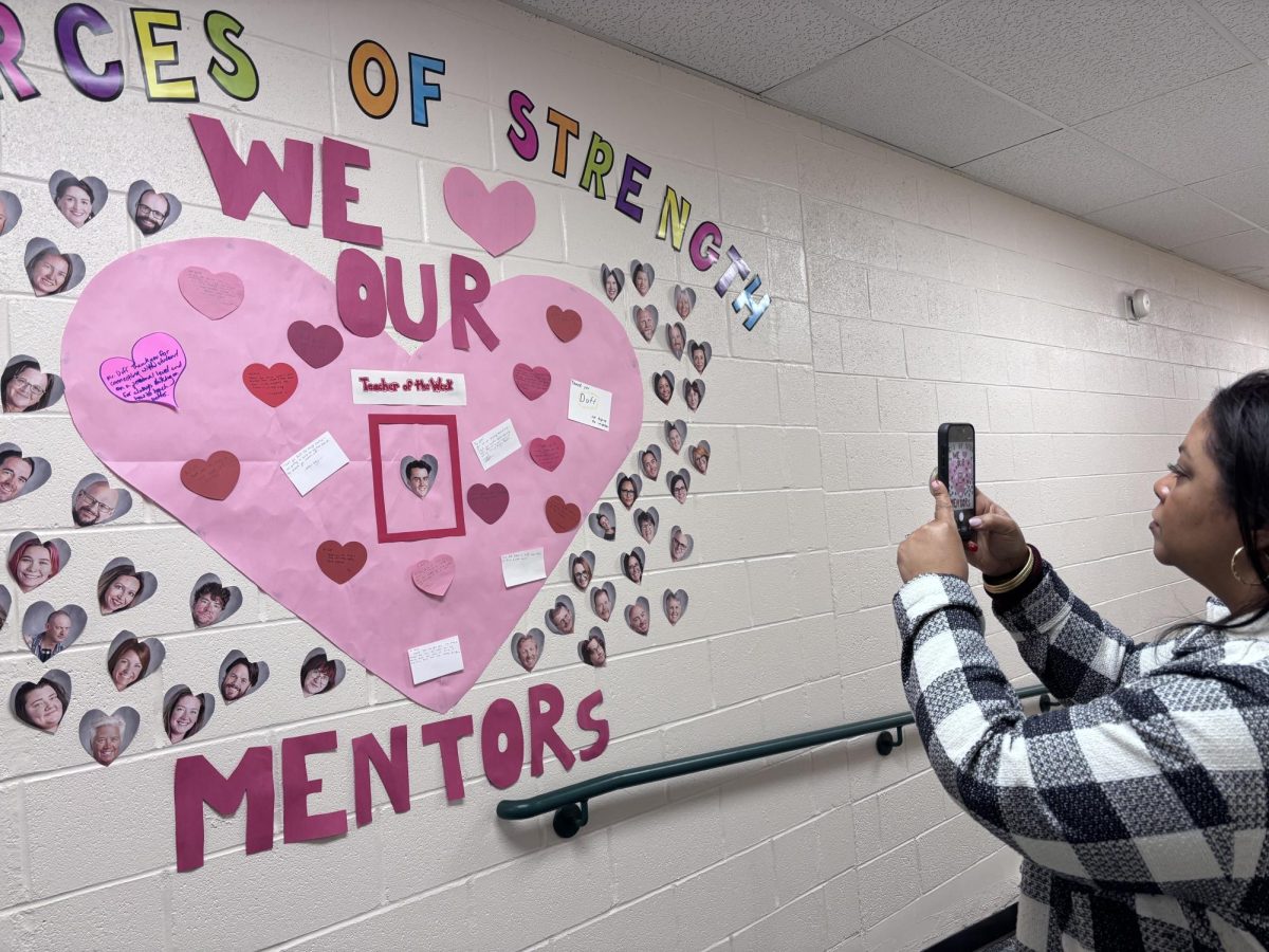 Ingrid Perez takes a photo of the new Sources of Strength mural outside of her room. It is one of her hobbies to take photos of things.